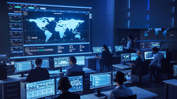 Team of Professional Computer Data Science Engineers Work on Desktops with Screens Showing Charts, Graphs, Infographics, Technical Neural Data and Statistics. Dark Control and Monitoring Room.